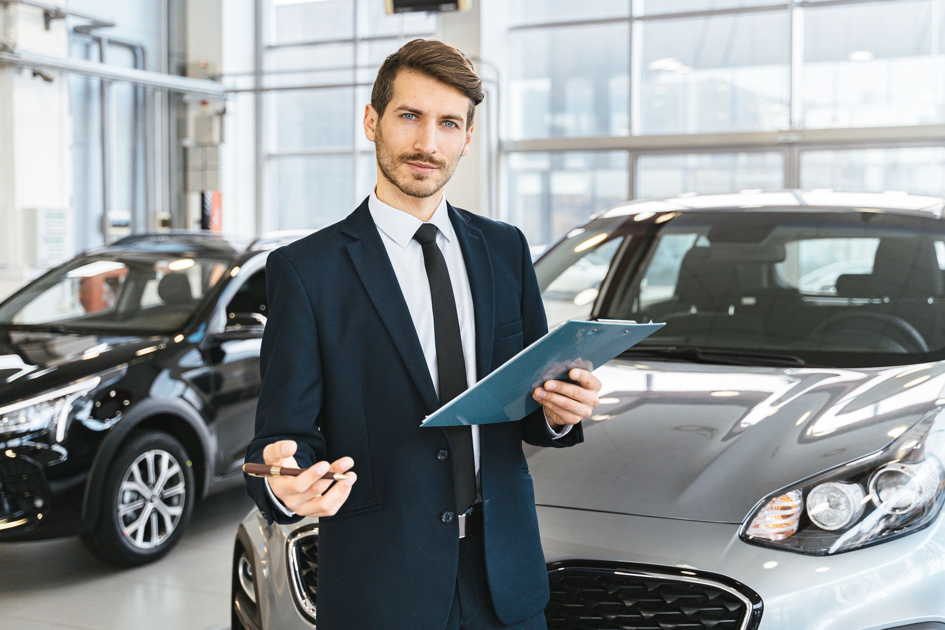 Vendedor com tablet em loja de carros